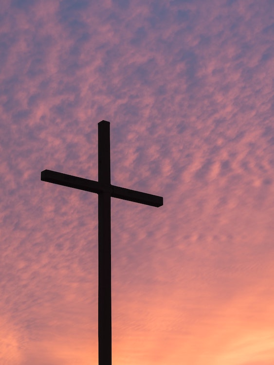 Cross against a purple sunset sky